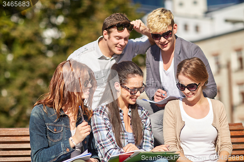 Image of group of happy students with notebooks at campus