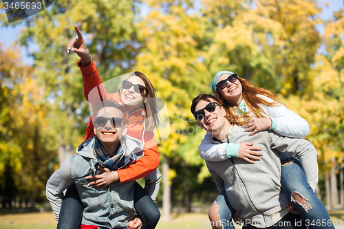 Image of happy friends in shades having fun at autumn park