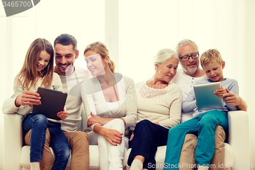 Image of smiling family with tablet pc at home