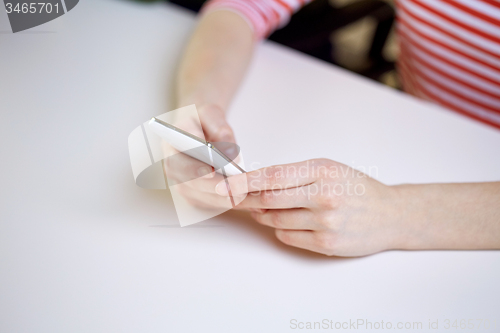 Image of close up of female hands with smartphone at home