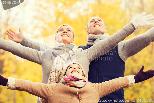 Image of happy family having fun in autumn park