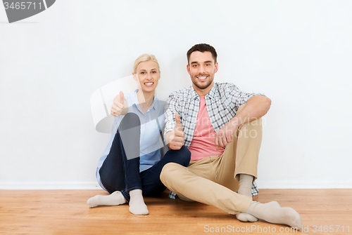Image of happy couple showing thumbs up at new home