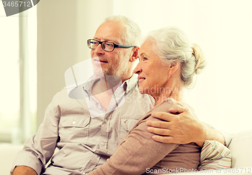 Image of happy senior couple sitting on sofa at home