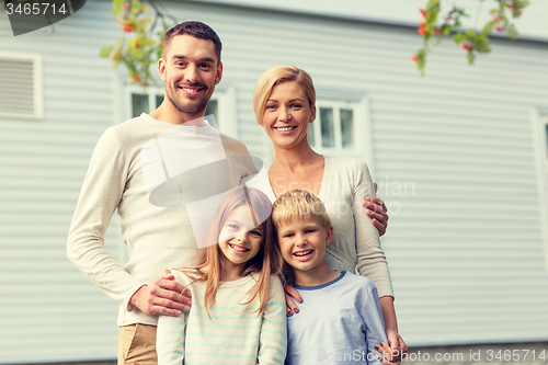 Image of happy family in front of house outdoors