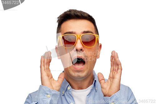 Image of face of scared man in shirt and sunglasses