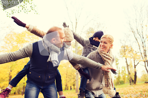 Image of happy family having fun in autumn park