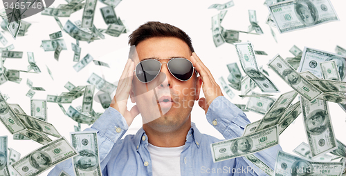 Image of surprised man under dollar money rain