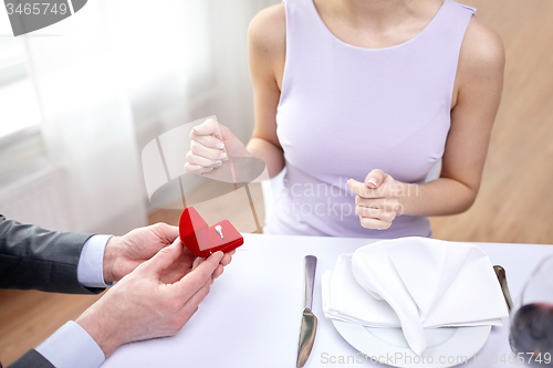 Image of excited young woman and boyfriend giving her ring