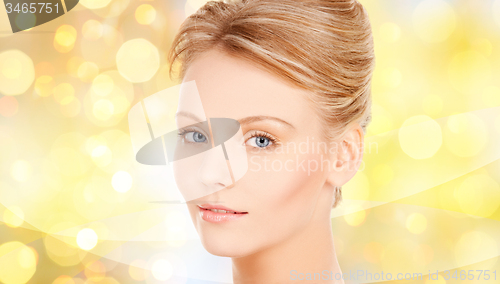 Image of beautiful young woman face over yellow lights