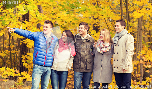 Image of group of smiling men and women in autumn park