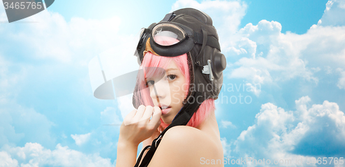 Image of pink hair girl in aviator helmet over blue sky