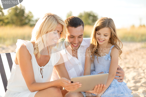 Image of smiling family at beach with tablet pc computer