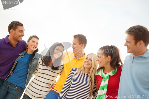 Image of group of happy friends hugging and talking
