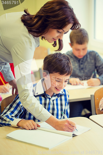 Image of group of school kids writing test in classroom