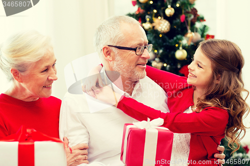 Image of smiling family with gifts at home