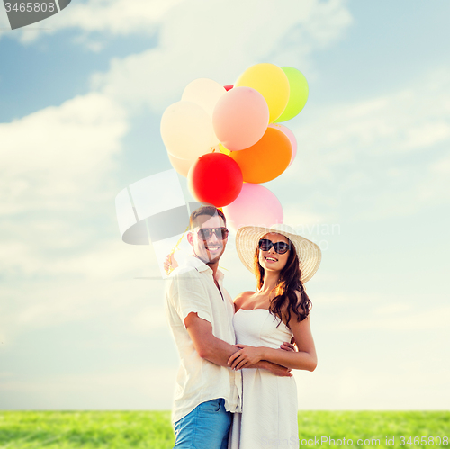 Image of smiling couple with air balloons outdoors