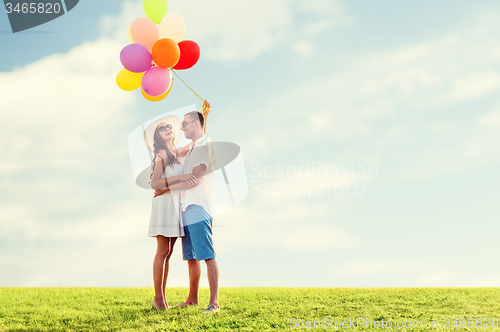 Image of smiling couple with air balloons outdoors