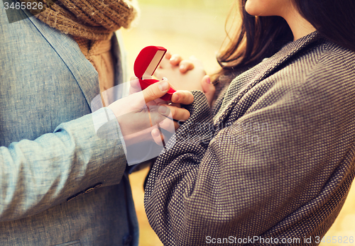 Image of close up of couple with gift box in park