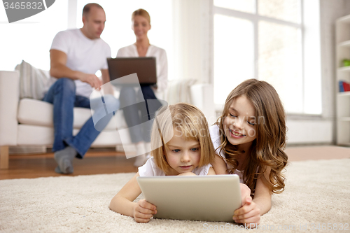 Image of happy little girls with tablet pc computer at home