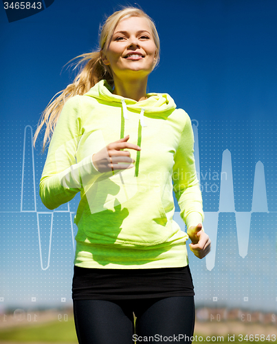 Image of smiling woman jogging outdoors