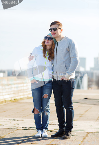 Image of happy teenage couple walking in city