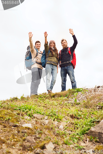 Image of group of smiling friends with backpacks hiking