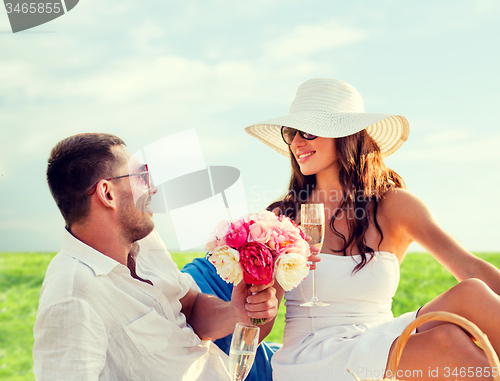 Image of smiling couple drinking champagne on picnic