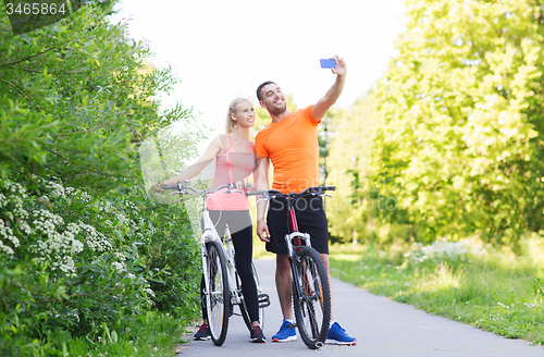 Image of couple with bicycle taking selfie by smartphone