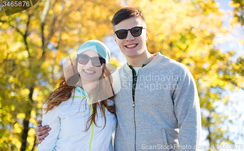 Image of happy teenage couple walking in autumn park