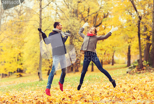 Image of smiling couple having fun in autumn park