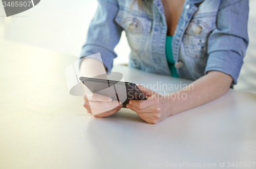 Image of close up of female hands with tablet pc at table