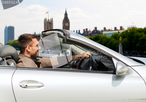 Image of happy man near cabriolet car over london city