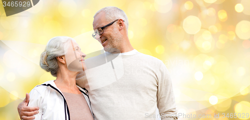 Image of happy senior couple over holiday lights background