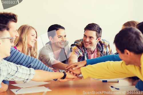 Image of group of smiling students with hand on top