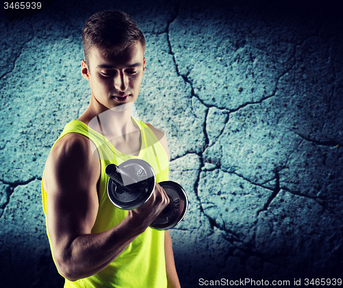 Image of young man with dumbbell flexing biceps