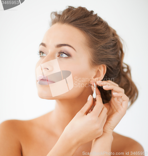 Image of woman wearing shiny diamond earrings