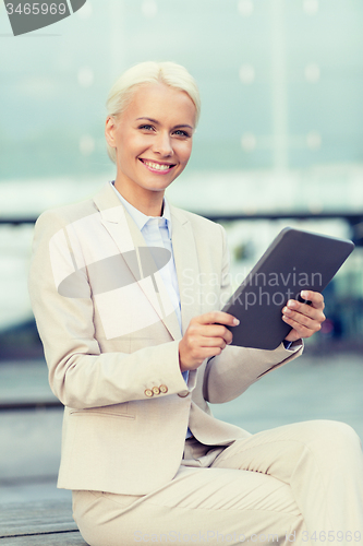 Image of smiling businesswoman with tablet pc outdoors