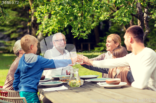 Image of happy family having holiday dinner outdoors