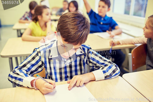 Image of group of school kids writing test in classroom