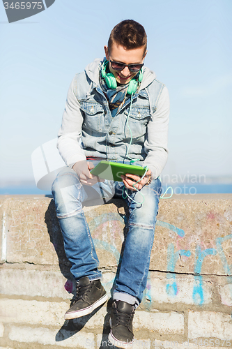 Image of happy young man with tablet pc and headphones