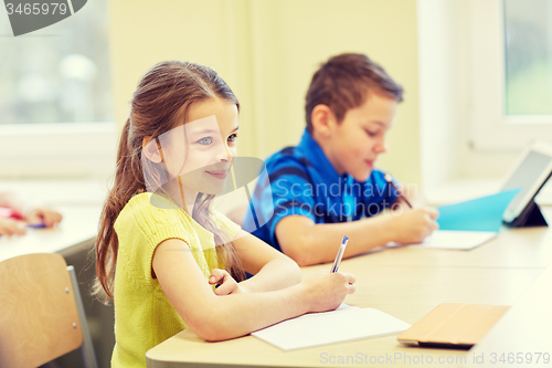 Image of group of school kids writing test in classroom