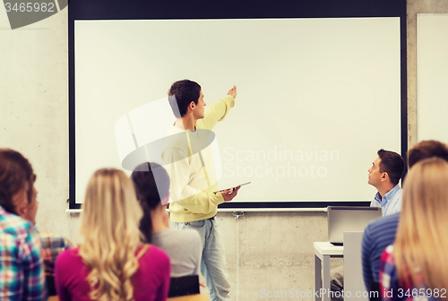 Image of group of smiling students and teacher in classroom