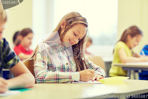 Image of group of school kids writing test in classroom