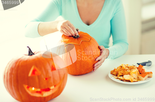 Image of close up of woman with pumpkins at home