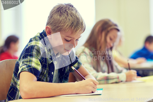 Image of group of school kids writing test in classroom