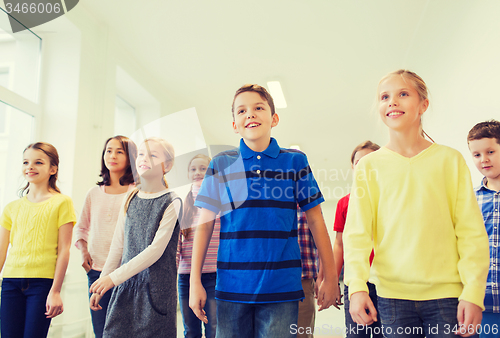 Image of group of smiling school kids walking in corridor