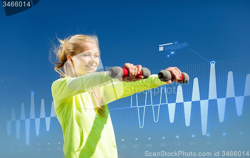 Image of sporty woman with light dumbbells outdoors