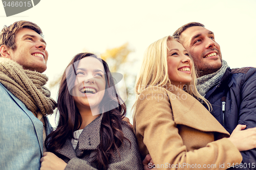 Image of group of smiling men and women in autumn park