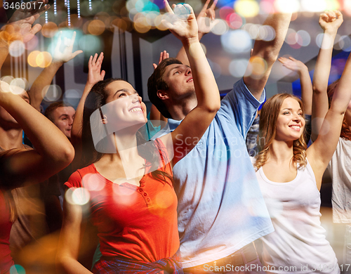 Image of smiling friends at concert in club