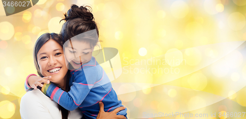 Image of happy mother and daughter hugging over lights